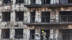 Un agente de la Policía Científica asoma en un balcón del edificio incendiado en Campanar (Valencia).