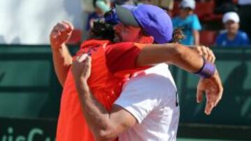 Christian Garín abraza a Nicolás Massú tras su victoria el viernes.