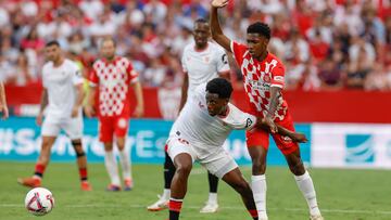 El delantero belga del Sevilla Dodi Lukebakio (i) lucha con Jhon Solis, del Girona, durante el partido de la cuarta jornada de LaLiga que Sevilla FC y Girona FC disputan hoy domingo en el estadio Ramón Sánchez-Pizjuán.