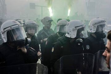Turkish anti-riot police stand next to burning torch before the Turkish Spor Toto Super league football match between Besiktas and Bursaspor at vodafone arena stadium on April 11