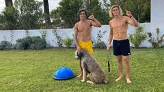 Jerome Cloetens y Liam Whaley en el patio de casa de Jerome en Tarifa, donde est&aacute;n pasando el confinamiento por coronavirus, con el perro y un Bosu, sin camiseta, listos para entrenar en el c&eacute;sped.