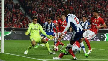 Benfica's Brazilian goalkeeper Ederson Santana (L) blocks a shot by Porto's Algerian midfielder Yacine Brahimi (2R) during the Portuguese league football match SL Benfica vs FC Porto at the Luz stadium in Lisbon on April 1, 2017. / AFP PHOTO / FRANCISCO LEONG