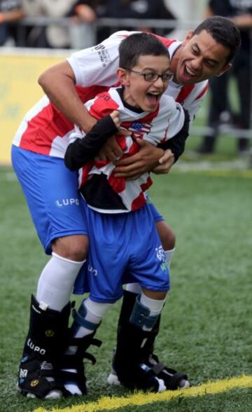 Gontijo jugador Brasileño con uno de los niños participantes en el  evento "Bota do Mundo" o "World Boots" , una cita apadrinada por el jugador del Barcelona y disputada por dieciséis niños de la Asociación de Asistencia de Niños Discapacitados (AACD) que hoy vieron realizado el sueño de compartir balón con algunos de sus ídolos.