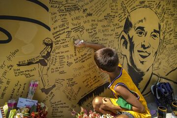 Un niño escribe en un mural de la ex estrella de la NBA Kobe Bryant en el exterior de la cancha de baloncesto "House of Kobe" en Valenzuela, Metro Manila, Filipinas.