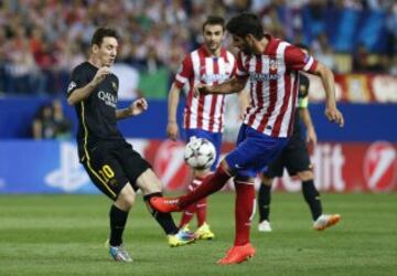 El delantero argentino del FC Barcelona Lionel Messi  lucha un balón con el centrocampista del Atlético de Madrid Raúl García, durante el partido de vuelta de cuartos de final de la Liga de Campeones que se disputa esta noche en el estadio Vicente Calderón.