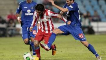 El centrocampista turco del Getafe Arda Turan controla el bal&oacute;n ante la oposici&oacute;n de los jugadores del Getafe, Xavier Torres y Miguel Torres durante el partido de vuelta de octavos de final de la Copa del Rey disputado esta tarde en el Coliseum Alfonso P&eacute;rez de Getafe. 