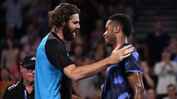 Reilly Opelka saluda a Giovanni Mpetshi Perricard en el Brisbane International.