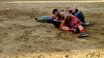 Jugadores compitiendo durante el partido final del Calcio Storico Fiorentino en la Piazza Santa Croce en Florencia.