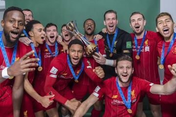 Divock Origi, Trent Alexander-Arnold, Andrew Robertson, James Milner, Joseph Gomez, Georginio Wijnaldum, Adrian, Adam Lallana, Jordan Henderson and Roberto Firmino pose with the Club World Cup trophy.