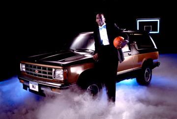 Michael vestido de esmoquin y una pelota de baloncesto bajo el brazo mientras posa con un automóvil Chevrolet durante un spot publicitario.