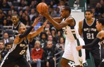 Patty Mills intenta robarle la pelota a Khris Middleton.