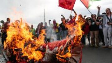 Un grupo de manifestantes queman una copa simbólica del Mundial de fútbol.