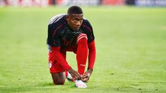 David Alaba se ata las botas antes de una partido de Champions con el Bayern.