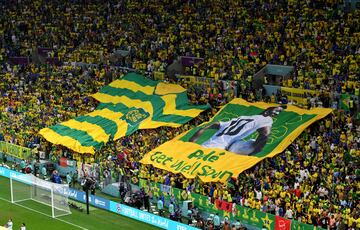 Aunque Brasil vistió de azul y blanco en su partido contra Camerún, el verde y el amarillo de los aficionados brasileños fue el color predominante en las gradas del estadio de Lusail. En la imagen, la hinchada de la pentacampeona despliega una camiseta y una pancarta gigantes deseando una pronta recuperación a su gran ídolo Pelé. El brasileño falleció el 29 de diciembre.