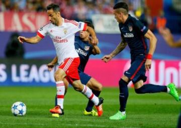 El delantero brasileño del Benfica Jonas Oliveira se escapa del uruguayo José María Giménez  y de Óliver Torres, del Atlético de Madrid.