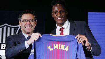 Barcelona's new Colombian defender Yerry Mina poses with his new jersey next to Barcelona football club president Josep Maria Bartomeu (L) during his official presentation in Barcelona on January 13, 2018. / AFP PHOTO / Pau Barrena
