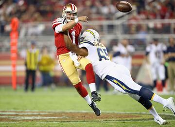 Nick Mullens (1), de los San Francisco 49ers es presionado por Whitney Richardson (65), de Los Angeles Chargers.