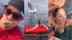 Una ballena salta frente a una chica, que ponen cara de miedo. 