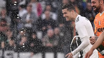 Juventus' Portuguese forward Cristiano Ronaldo and Juventus' Italian goalkeeper Carlo Pinsoglio (r) celebrate with champagne after Juventus secured its 8th consecutive Italian 2018/19 "Scudetto" Serie A championships, after winning the