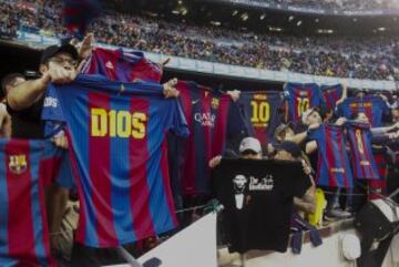 Aficionados del FC Barcelona muestran camisetas del delantero argentino Leo Messi.