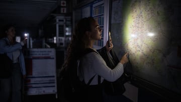 Una mujer ilumina con la linterna del móvil un plano de la red de Metro de Madrid en una estación, el 28 de abril de 2025 en Madrid, España.
Alejandro Martínez Vélez / Europa Press
28/04/2025