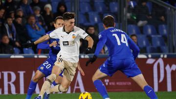 GETAFE, 08/12/2023.- El centrocampista del Valencia, Pepelu (c), con el balón ante los jugadores del Getafe, el esloveno Nemanja Maksimovic (i) y Latasa, durante el encuentro correspondiente a la jornada 16 de primera división que disputan hoy viernes Getafe y Valencia en el Coliseum de Getafe. EFE / Zipi Aragón.
