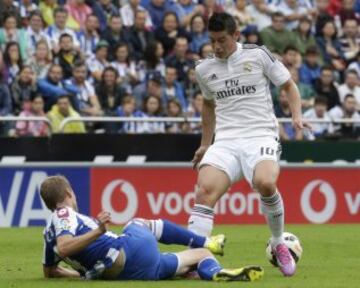 El centrocampista colombiano del Real Madrid James Rodríguez (d) lucha por un balón con el centrocampista argentino del Deportivo Luis Fariña (i).