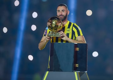 Karim Benzema lifts the Ballon d'Or trophy as being presented to the Al-Ittihad crowd.