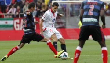 El delantero del Sevilla Víctor Machín "Vitolo" (c) y el defensa francés del Granada Alexandre Coeff (i) luchan por el balón.