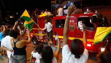 AME1248. BUENAVENTURA (COLOMBIA), 14/04/2022.- Ciudadanos expresan hoy su apoyo mientras una caravana traslada los restos mortales del exfutbolista colombiano Freddy Rincón, en Buenaventura (Colombia). Los familiares del 'Coloso de Buenaventura', que llenó de orgullo al país con su fútbol y que falleció en la noche del miércoles a los 55 años de edad tras sufrir un accidente de tráfico en Cali dos días antes, decidieron trasladar sus restos a su tierra natal, donde fue homenajeado este jueves. EFE/ Ernesto Guzmán Jr
