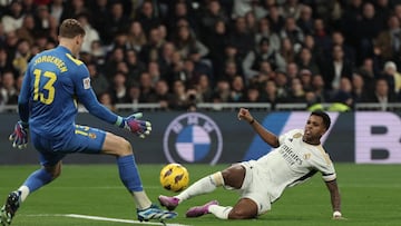 Villarreal's Danish goalkeeper #13 Filip Jorgensen prepares to save a shot from Real Madrid's Brazilian forward #11 Rodrygo during the Spanish league football match between Real Madrid CF and Villarreal CF at the Santiago Bernabeu stadium in Madrid on December 17, 2023. (Photo by Thomas COEX / AFP)