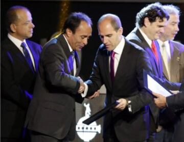 Chile's former soccer player Jaime Pizarro (2nd L) receives an award in honor of his career from Sergio Jadue, president of Chile's Football Federation (3nd R), during the draw for the 2015 Copa Libertadores at the CONMEBOL headquarters in Luque, on the outskirts of Asuncion, December 2, 2014. REUTERS/Jorge Adorno (PARAGUAY - Tags: SPORT SOCCER)