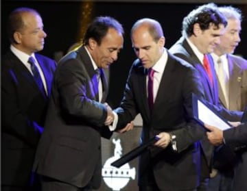 Chile's former soccer player Jaime Pizarro (2nd L) receives an award in honor of his career from Sergio Jadue, president of Chile's Football Federation (3nd R), during the draw for the 2015 Copa Libertadores at the CONMEBOL headquarters in Luque, on the outskirts of Asuncion, December 2, 2014. REUTERS/Jorge Adorno (PARAGUAY - Tags: SPORT SOCCER)