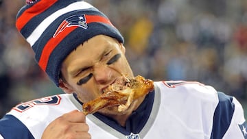 Nov 22, 2012; East Rutherford, NJ, USA; New England Patriots quarterback Tom Brady (12) takes a bite of turkey drumstick after the game against the New York Jets on Thanksgiving at Metlife Stadium. The Patriots won the game 49-19. Mandatory Credit: Joe Ca