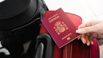 Unrecognizable female hand catches a Spanish European passport on luggage.