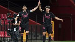 Real Madrid&#039;s French forward Karim Benzema (L) celebrates scoring a goal with Real Madrid&#039;s Spanish defender Miguel Gutierrez during the Spanish league football match Granada FC against Real Madrid CF at the Nuevo Los Carmenes stadium in Granada