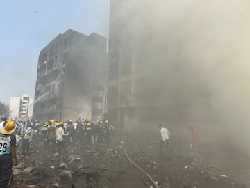 Los miembros del equipo de rescate trabajan mientras el humo se eleva en el lugar donde se estrell un avin de Air India en Ahmedabad.
