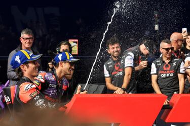 Maverick Viñales celebra lanzando champán a sus compañeros del equipo Aprilia.