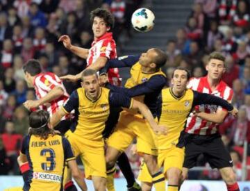 El defensa del Athletic Club Mikel San José remata ante varios jugadores del Atlético de Madrid.