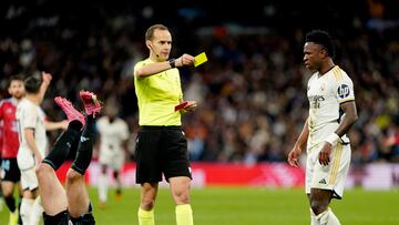 Soccer Football - LaLiga - Real Madrid v Celta Vigo - Santiago Bernabeu, Madrid, Spain - March 10, 2024 Real Madrid's Vinicius Junior is shown a yellow card by referee Mario Melero Lopez REUTERS/Ana Beltran
