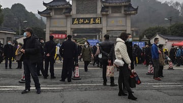 People are seen outside the Biandanshan cemetery in Wuhan, in China's central Hubei province on February 12, 2021, during the first day of the Lunar New Year, which ushers in the Year of the Ox. (Photo by Hector RETAMAL / AFP)
