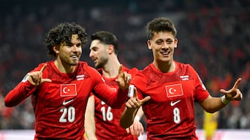 Turkey's defender #20 Ferdi Kadioglu (L) celebrates with Turkey's midfielder #16 Ismail Yuksek (C) and Turkey's midfielder #08 Arda Guler (R) after scoring his team first goal during the play-off FIFA World Cup 2026 European qualification knockout semi-final football match between Turkey and Romania at Besiktas Park stadium, in Istanbul on March 26, 2026. (Photo by YASIN AKGUL / AFP)