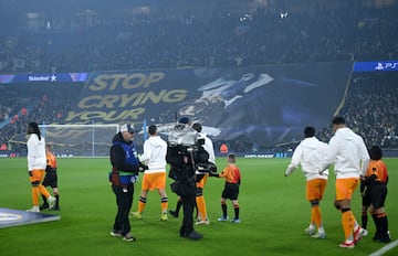 Los jugadores del Real Madrid salen al terreno de juego con la pancarta de los aficionados del City de fondo.