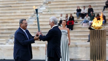 ATHENS (Greece), 04/12/2025.- President of the Greek Olympic Committee Isidoros Kouvelos (L) hands over the torch with the Olympic Flame to Giovanni Malago, President of the Milano Cortina 2026, during the handover ceremony of the Olympic Flame for the Milano Cortina 2026 Winter Olympics, at the Panathenaic Stadium in Athens, Greece, 04 December 2025. (Grecia, Atenas) EFE/EPA/ORESTIS PANAGIOTOU