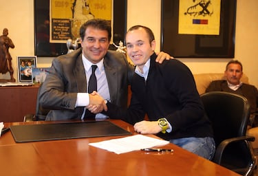 Joan Laporta y Andrés Iniesta se dan un apretón de manos tras firmar la renovación del futbolista albaceteño con el FC Barcelona. 
