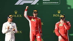 Ferrari&#039;s German driver Sebastian Vettel (C) celebrates his victory on the podium next to second-placed Mercedes&#039; British driver Lewis Hamilton (L) and third-placed Ferrari&#039;s Finnish driver Kimi Raikkonen (R) after the Formula One Australian Grand Prix in Melbourne on March 25, 2018. / AFP PHOTO / WILLIAM WEST / -- IMAGE RESTRICTED TO EDITORIAL USE - STRICTLY NO COMMERCIAL USE --