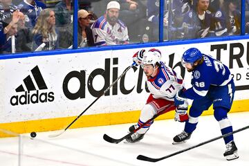 TAMPA, FLORIDA - JUNE 11: Frank Vatrano #77 of the New York Rangers skates with the puck against Brandon Hagel #38 of the Tampa Bay 