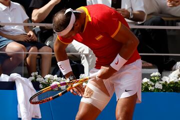 Nadal se coloca el vendaje del muslo durante el segundo set. 
