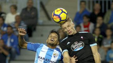 Daniel Wass salta para golpear de cabeza el balón junto a Rosales, jugador del Málaga.