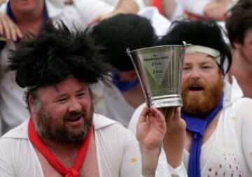 Los capitanes de ambos equipos Chris Summerhayes (Centro derecha) de los Blue Suede Shoes, y Dave Nichols (Centro izquierda) de los Reddy Teddies con el trofeo de la Copa Memphis después de que su partido de rugby, como es tradición  terminara en empate.